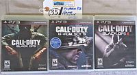 Front covers of the three PS3 Call of Duty games showing Black Ops, Ghosts, and Black Ops II with original case art and ESRB rating.