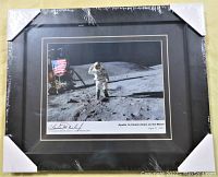 Framed and sealed signed photo of astronaut Charles Duke on the lunar surface next to American flag and lunar module.