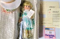 Photo of the Marie Osmond Cherish Easter Porcelain Doll in original box with bubble wrap and certificate of authenticity visible.