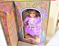 Boxed vintage Marie Osmond porcelain doll in lavender dress visible through window