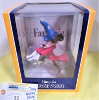 Front view of the boxed Disney Fantasia Mickey Mouse vinyl doll, showing the character wearing a blue wizard hat and red robe.