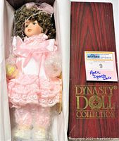 Full view of the vintage April Dynasty Doll in box with protective bubble wrap and original wooden style box lid.