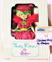 Front view of vintage Effanbee Christmas Fairy doll in original box showing doll dressed in red dress with green trim and red hat with green ribbon, blonde hair visible.