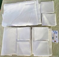 All three tablecloths and six napkins folded and displayed on flat surface