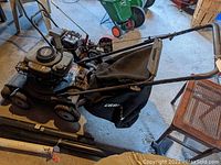 Side angled view of the Craftsman mower showing the black mulch bag, metal frame, and engine housing with Craftsman branding.