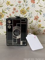 Front view of Kodak Beau Brownie BR1 camera showing geometric black and silver design and two lens openings.