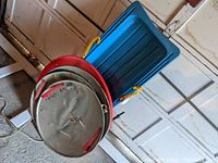 Overview of all sleds including the blue plastic sled and three metal dish sleds