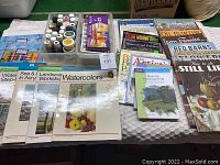 Photo showing multiple art instruction books and magazines with various painting techniques and subjects