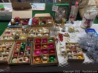 Overall assortment of boxes containing vintage glass ball ornaments, tree toppers, tinsel garland and hooks