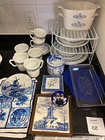 Full view of the lot showing mugs, plates, canister, trivet, and glass tray with blue and white patterns.