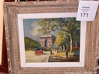 Framed oil painting depicting L'Arc de Triomphe scene with pedestrians and cars.