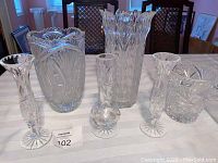 Photo showing all six crystal vases arranged on table, three large and three bud vases with pinwheel pattern