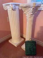 Pair of ceramic pillars displayed standing side by side, showing overall profile and size difference.