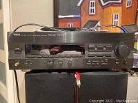 Front view of Yamaha RX-V492 stereo receiver showing power button, volume knob, speaker selector switches, headphones jack, bass, treble, and balance controls.