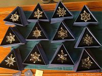 Twelve boxed crystal ornaments arranged in rows on table