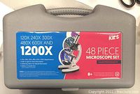Gray carrying case with label showing microscope magnifications and 48 piece set