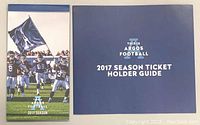 Photo showing the 2017 Toronto Argos Season Ticket Holder Guide booklet with blue cover.