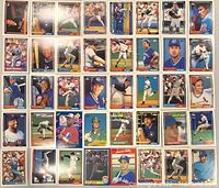 Photo of a large assortment of baseball cards feature a variety of players in different poses, in various card designs and colors from multiple manufacturers.