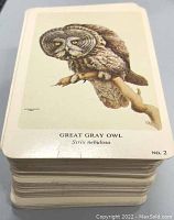 Stack of bird-themed cigar cards showing edges and card backs, slight wear visible