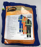 Image of original packaging showing the Pioneer Flame Resistant/Arc Rated Cotton Safety Coverall with safety features, certifications, and color options.