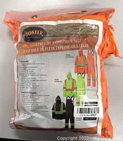 Photo of sealed Pioneer brand packaging showing label of lightweight waterproof suit with images of jacket and pants in orange, lime green, and black color options, size 4XL