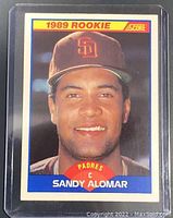 Front of the 1989 Score rookie card showing headshot of Sandy Alomar wearing Padres cap with team logo and 1989 Rookie, Score branding.