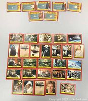 Top view of 34 Star Wars Return of the Jedi trading cards laid out in rows, showing a mix of character and scene images with red and yellow borders.