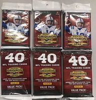 Three unopened packs of Panini Gridiron Gear 2010 NFL trading cards showing front packaging with Peyton Manning and value pack details.