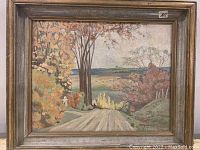 Full view of the framed oil painting showing autumn landscape with dirt road, trees, and distant fields.