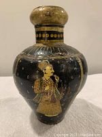 Front view of the antique Persian water jug showing a hand-painted figure of a man on black background with gold accents.
