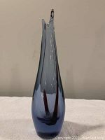 Full front view of the mid-century modern bud vase showing its tall, tapered shape with smoky gray-blue color and two dark internal streaks.
