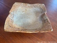 Three-quarter angle view of the square studio pottery bowl showing texture and glaze.