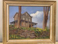 Full view of oil painting showing the house, trees and sky with its frame.