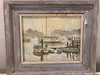 Full view of framed harbour boat painting showing the boats, water, and background buildings.