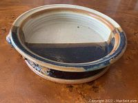 Side angle photo showing the full ceramic bowl with its glaze colors and handle detail