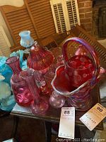 Overview of rose and pink glassware including basket vase, candy bowl, and vases.