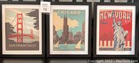 Shows three framed travel posters displayed side by side: San Francisco, Chicago, New York