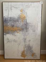 Full view of abstract canvas painting showing gold, gray, and white tones with gold frame