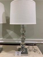 Single crystal sphere chrome finish table lamp showing stacked crystal spheres and white fabric shade