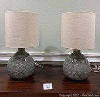 Front view of both lamps side by side on wooden surface
