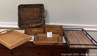 Front view of all trays arranged on wooden dresser showcasing variety in styles and materials