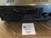 Front view of Kenwood receiver powered on with display indicating input mode A-PHONO.