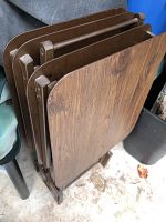 Four wooden snack trays with rounded corners arranged vertically in a wooden stand holder. Trays have a dark wood grain finish.