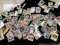 Overview photo showing scattered vintage baseball cards on black background