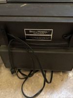 Photo showing side of vintage Bell & Howell Autoload projector unit with attached power cord and brand labeling on casing