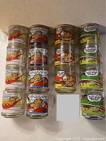 Top view showing all 15 Garfield comic mugs arranged grouped by sets of four and three, showcasing the colorful comic strip graphics on each glass.