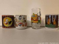Photo of four cartoon character cups: Casper, Snow White, Snoopy, and Far Side designs.