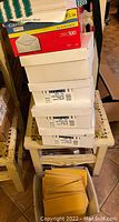Photo of stacked boxes of business envelopes on a small table with additional manila envelopes.