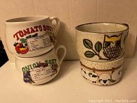 Four ceramic soup bowl mugs grouped, showing two with soup names 'Tomato Soup' and 'Onion Soup' with nutrition facts labels, and one with owl and sheep design.