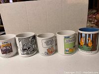 Photo of 5 coffee mugs showing various classic Sunday funnies comics on each mug.